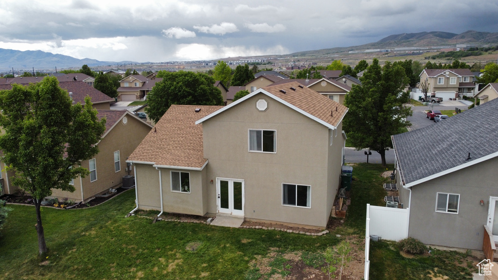 Rear view of house with a residential view, a mountain view, and stucco siding