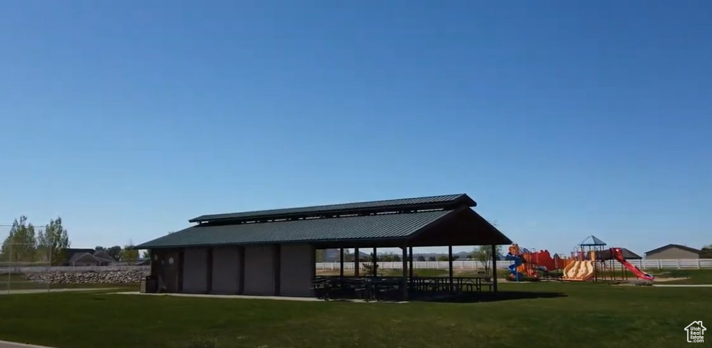 Back of house with a playground and a lawn