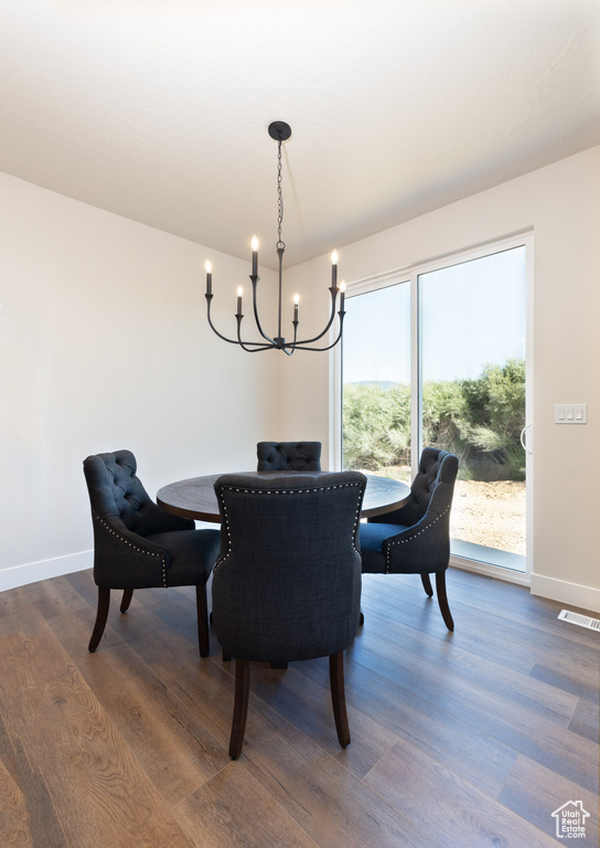 Dining area featuring a chandelier, dark wood-style floors, and baseboards