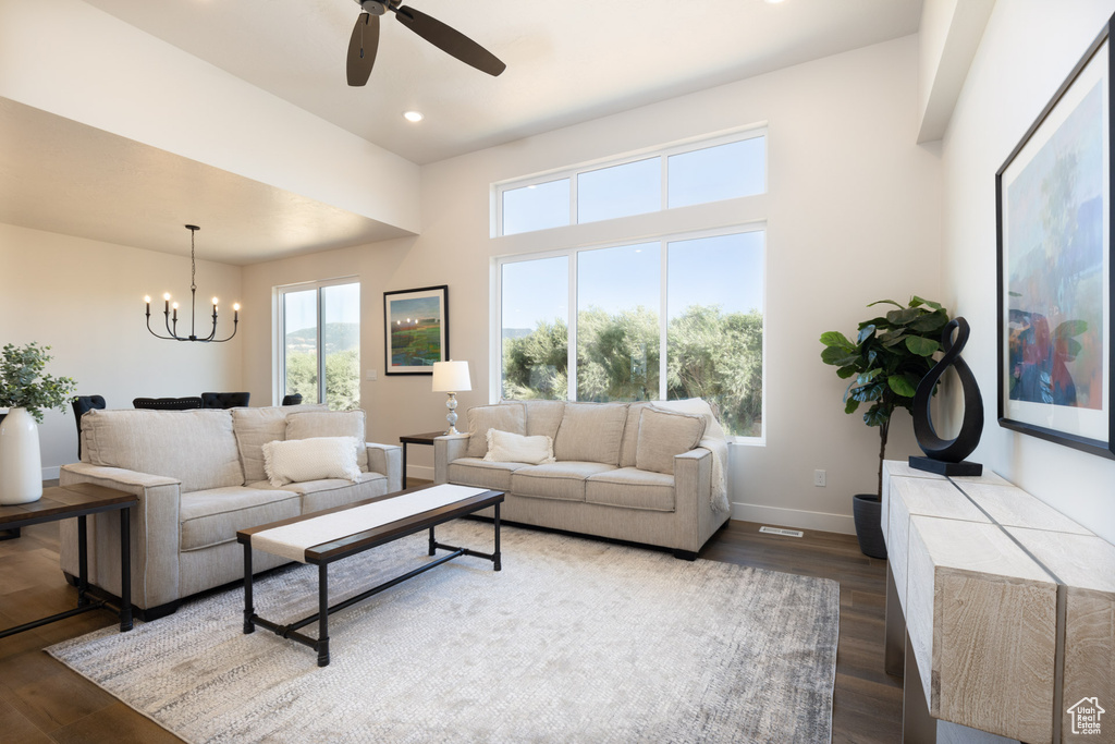 Living area with a chandelier, healthy amount of natural light, wood finished floors, ceiling fan, and recessed lighting