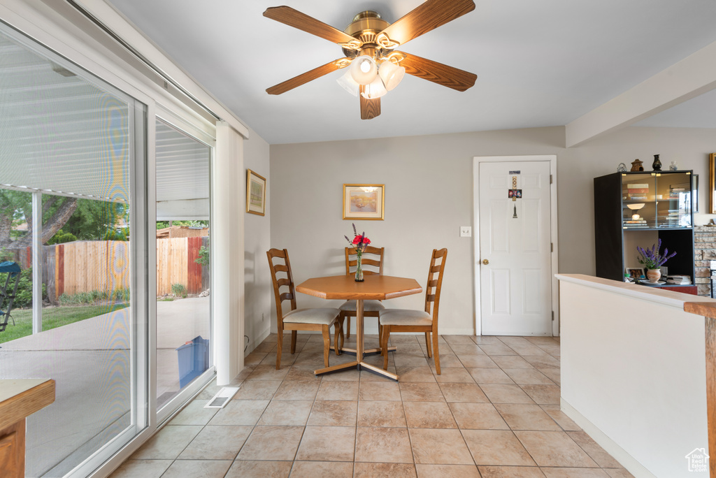 Dining area with ceiling fan, light tile patterned flooring, and baseboards