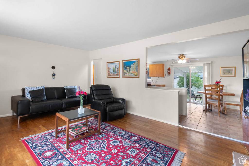 Living area with wood finished floors, baseboards, and ceiling fan