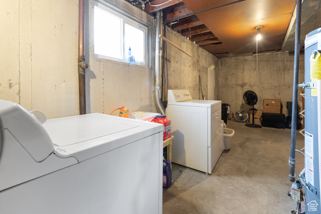 Basement featuring washer and clothes dryer and water heater