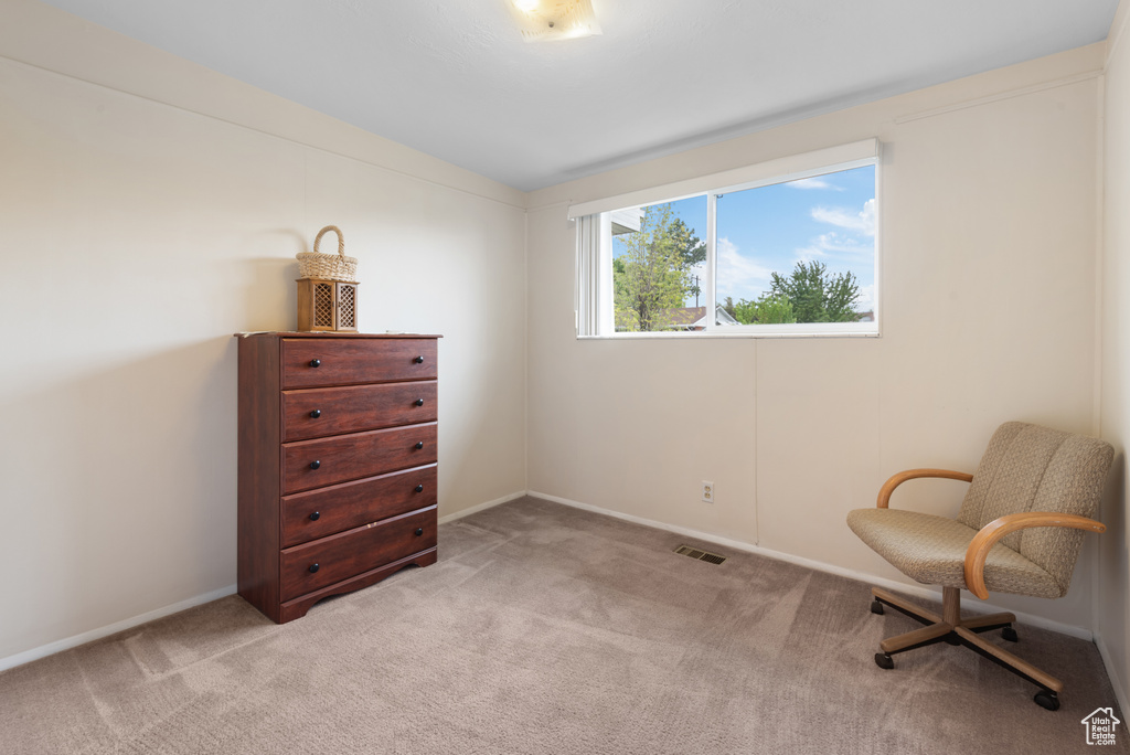 Living area with light colored carpet and baseboards