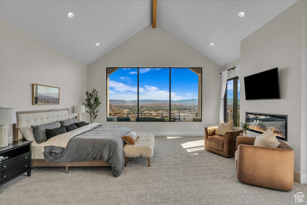 Bedroom with light carpet, beam ceiling, high vaulted ceiling, recessed lighting, and a glass covered fireplace