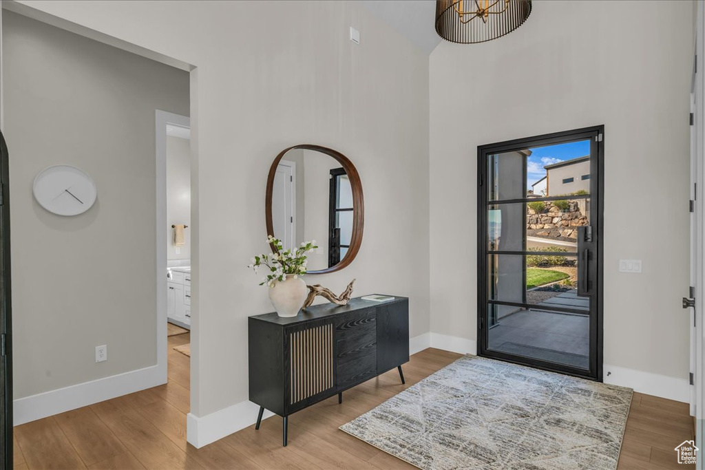 Foyer with wood finished floors, baseboards, and a high ceiling