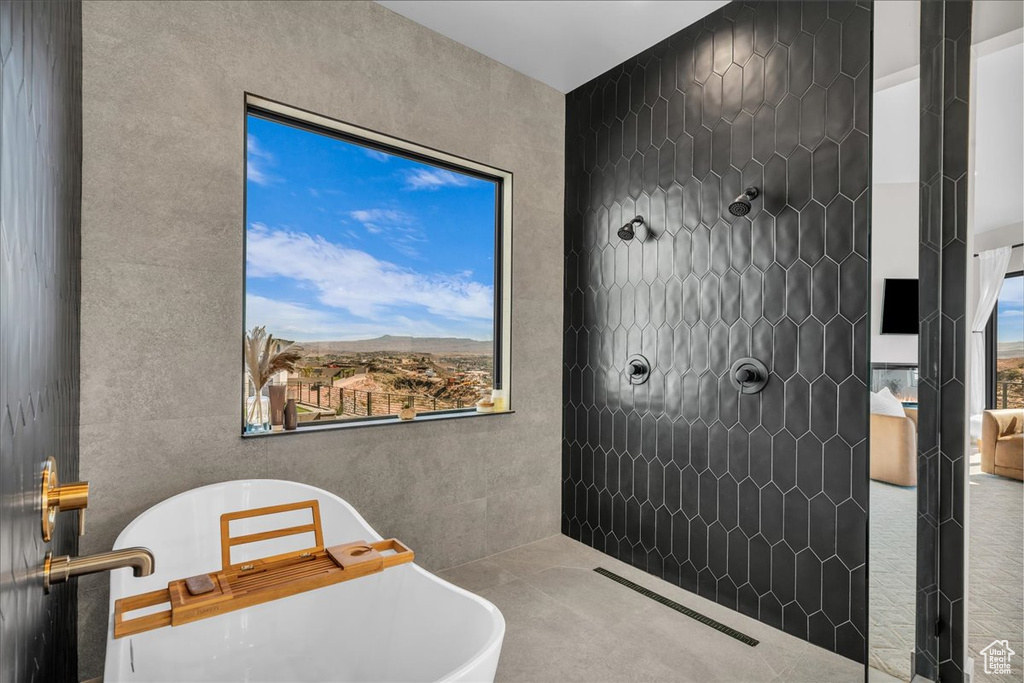 Full bathroom featuring a soaking tub and tiled shower
