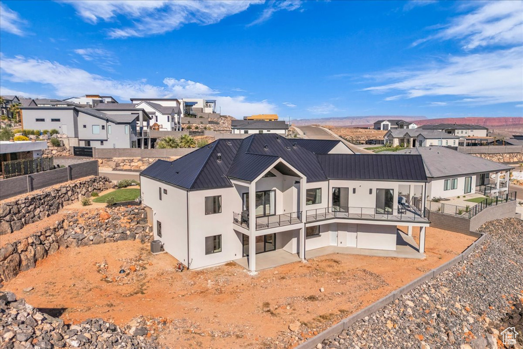 Rear view of house featuring stucco siding, a residential view, a fenced backyard, and a patio