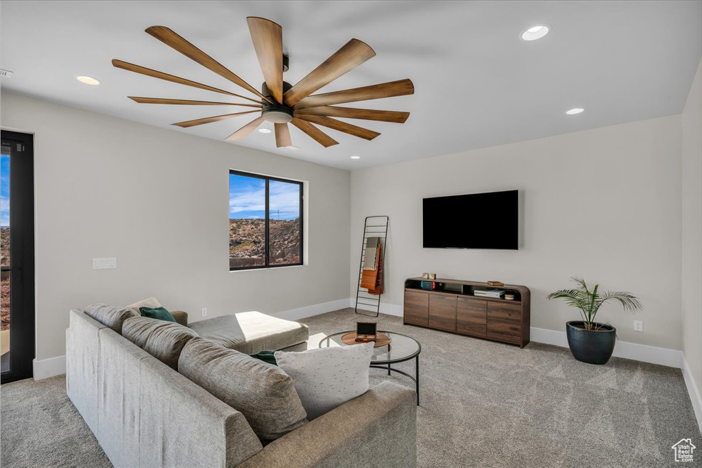 Carpeted living room featuring a ceiling fan, recessed lighting, and baseboards