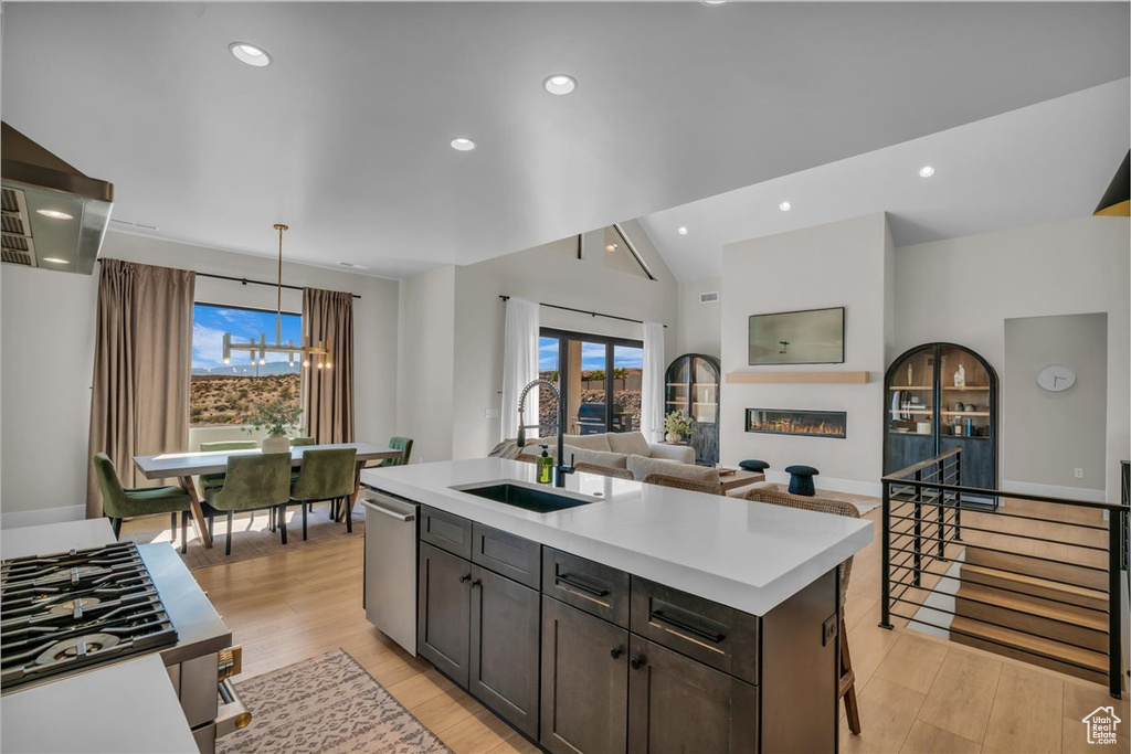 Kitchen with a sink, light countertops, healthy amount of natural light, open floor plan, and recessed lighting