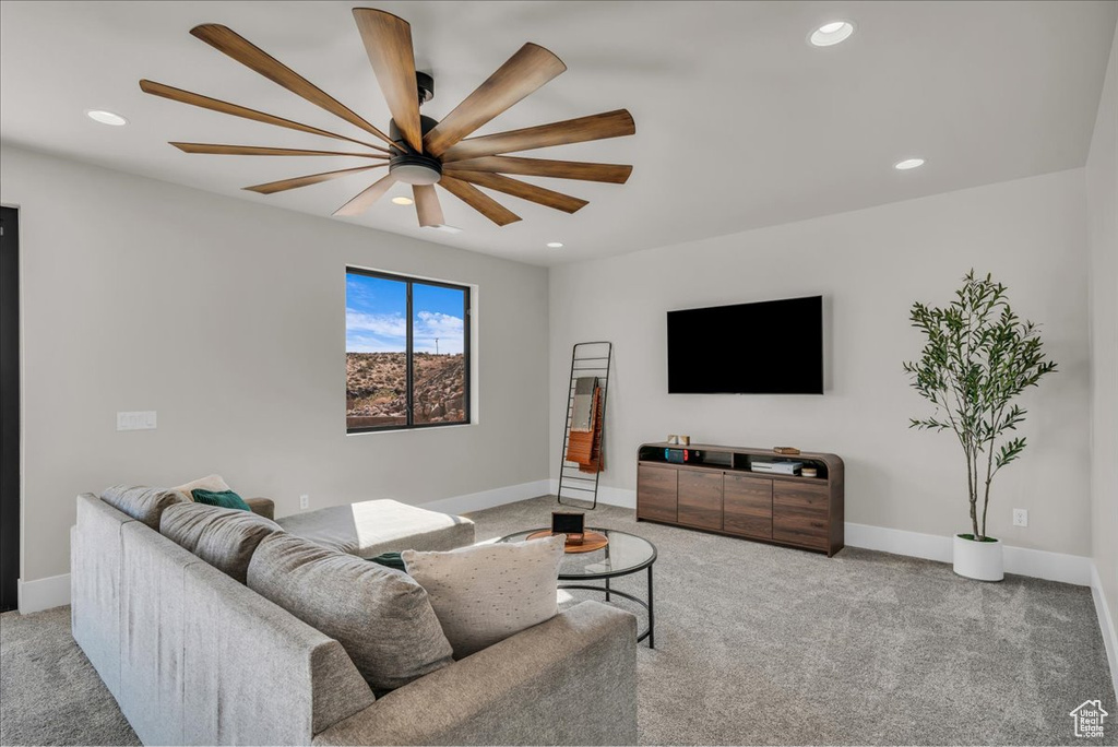 Carpeted living area with a ceiling fan, recessed lighting, and baseboards