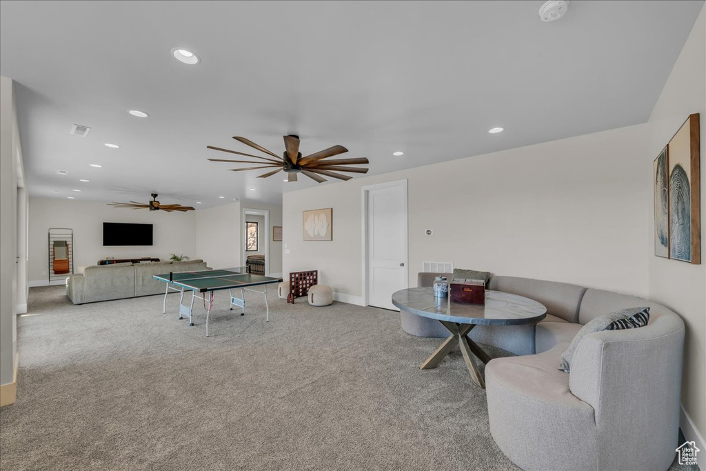 Carpeted living area featuring a ceiling fan, recessed lighting, and baseboards