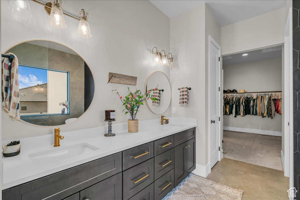 Bathroom with double vanity and a walk in closet