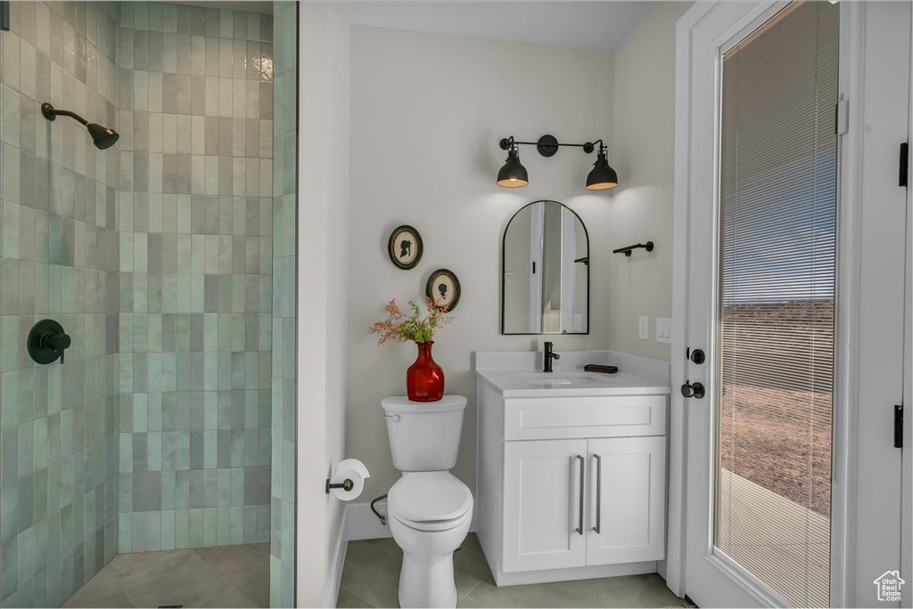 Bathroom with a tile shower, toilet, and vanity