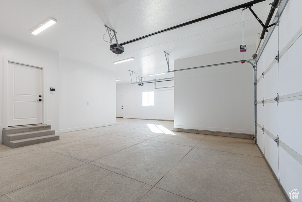 Garage with a garage door opener and baseboards