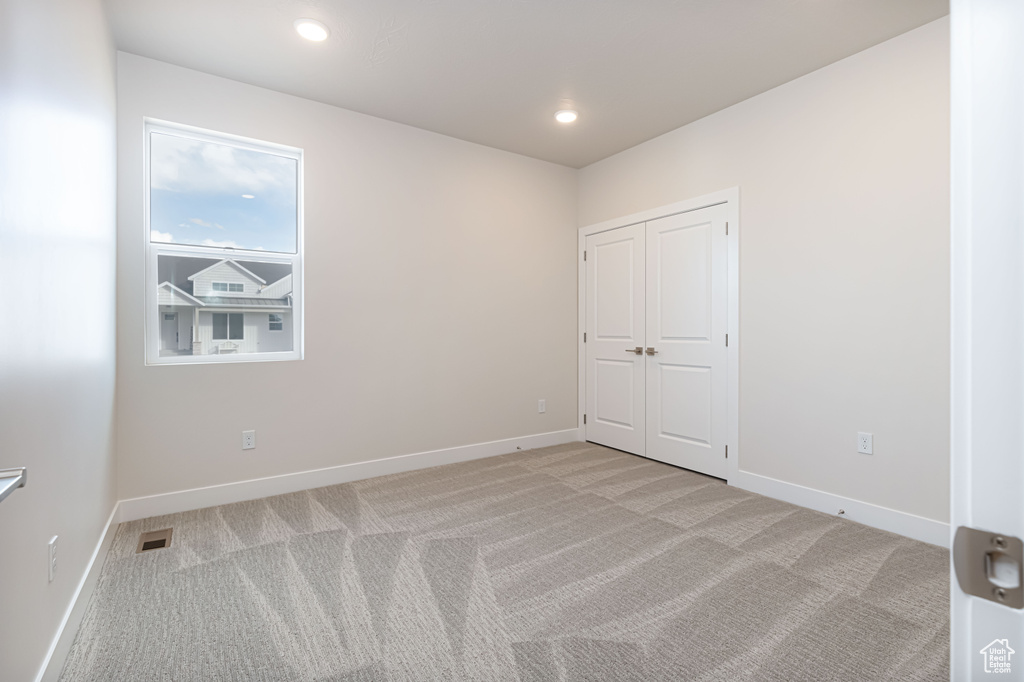 Spare room with light colored carpet, baseboards, and recessed lighting