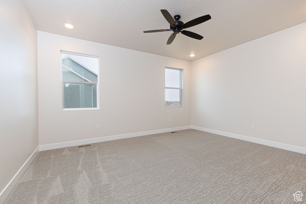 Unfurnished room featuring light colored carpet, a ceiling fan, recessed lighting, and baseboards