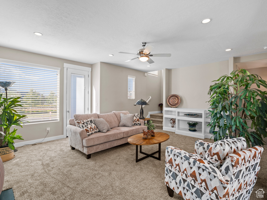 Carpeted living area featuring recessed lighting, ceiling fan, and baseboards