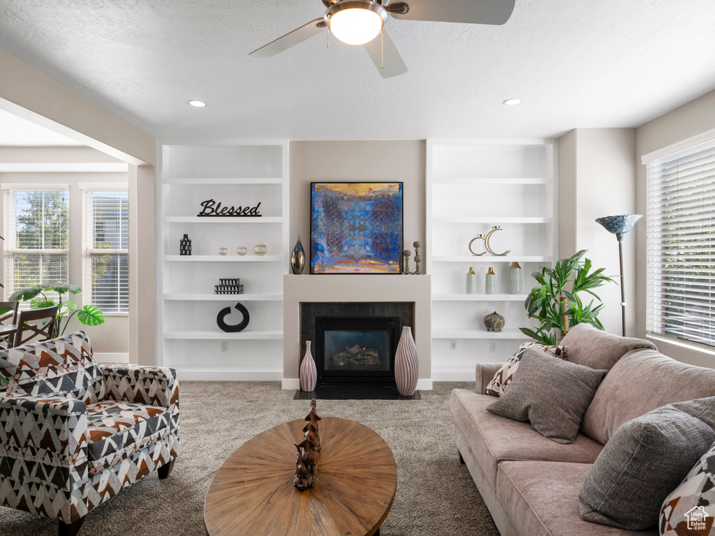 Carpeted living area featuring a ceiling fan, a tile fireplace, a textured ceiling, and recessed lighting