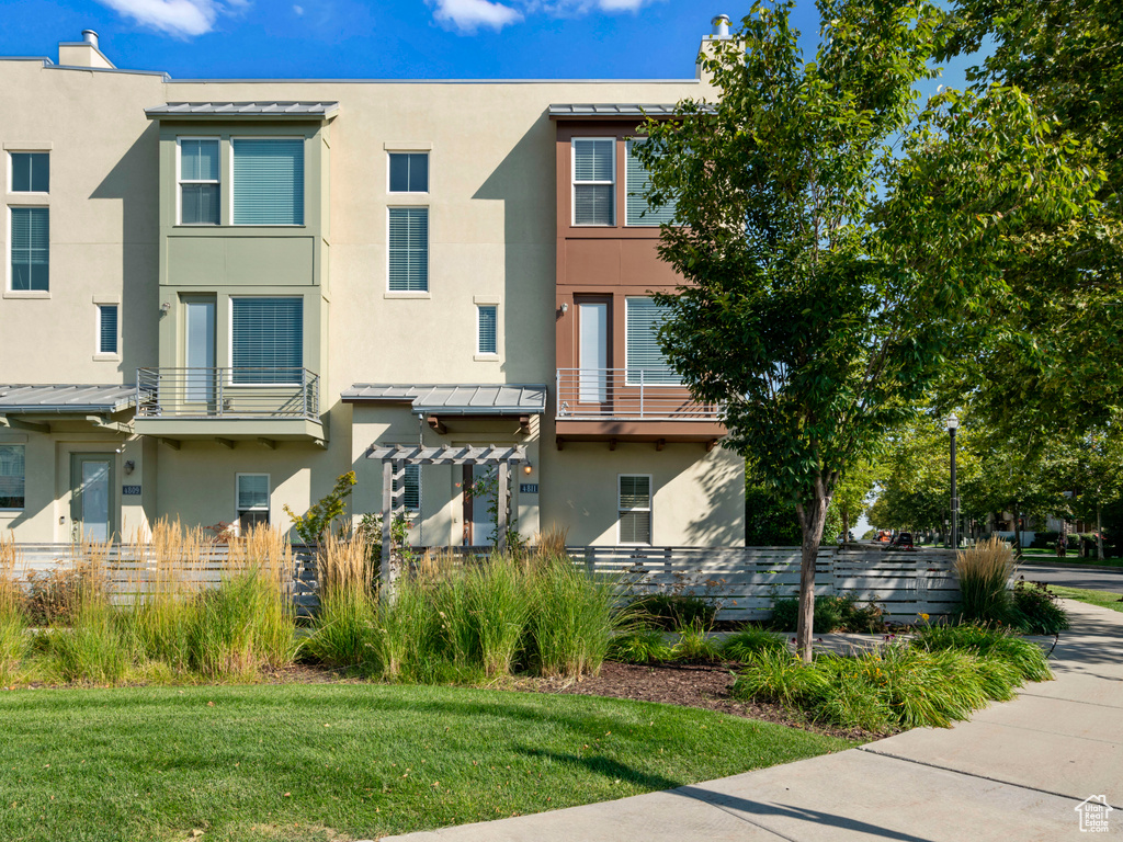 Townhome / multi-family property featuring stucco siding, a standing seam roof, and metal roof
