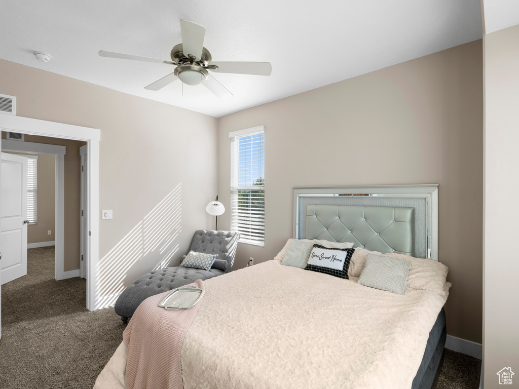 Carpeted bedroom featuring baseboards and ceiling fan