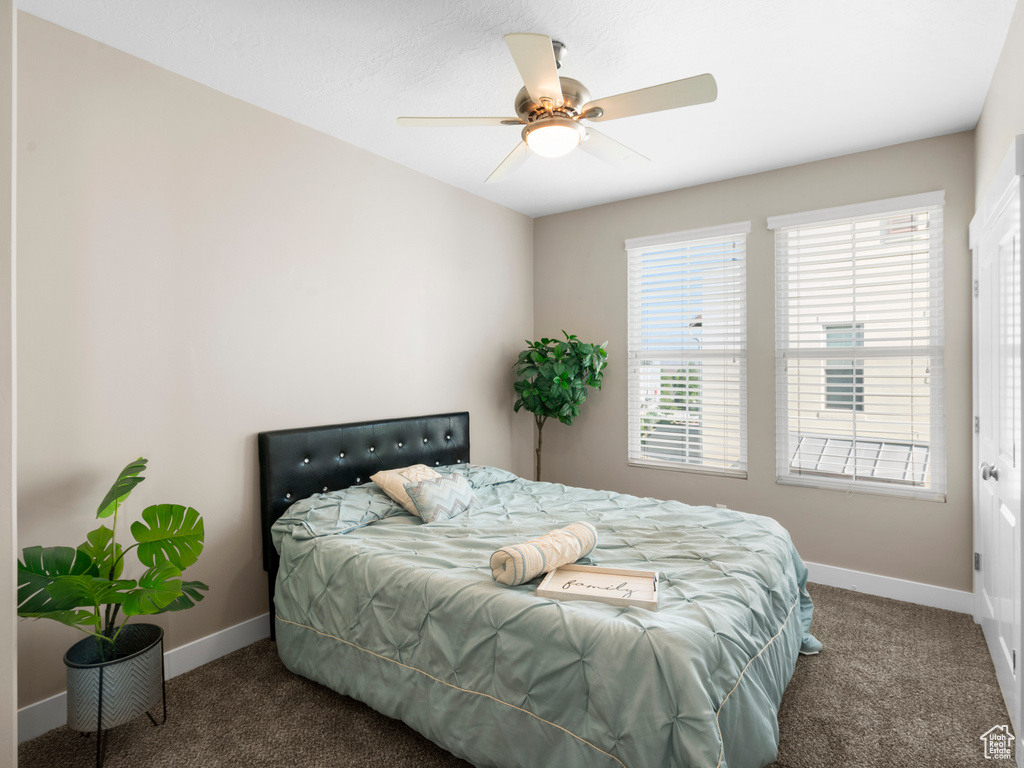 Bedroom with carpet flooring, baseboards, and a ceiling fan