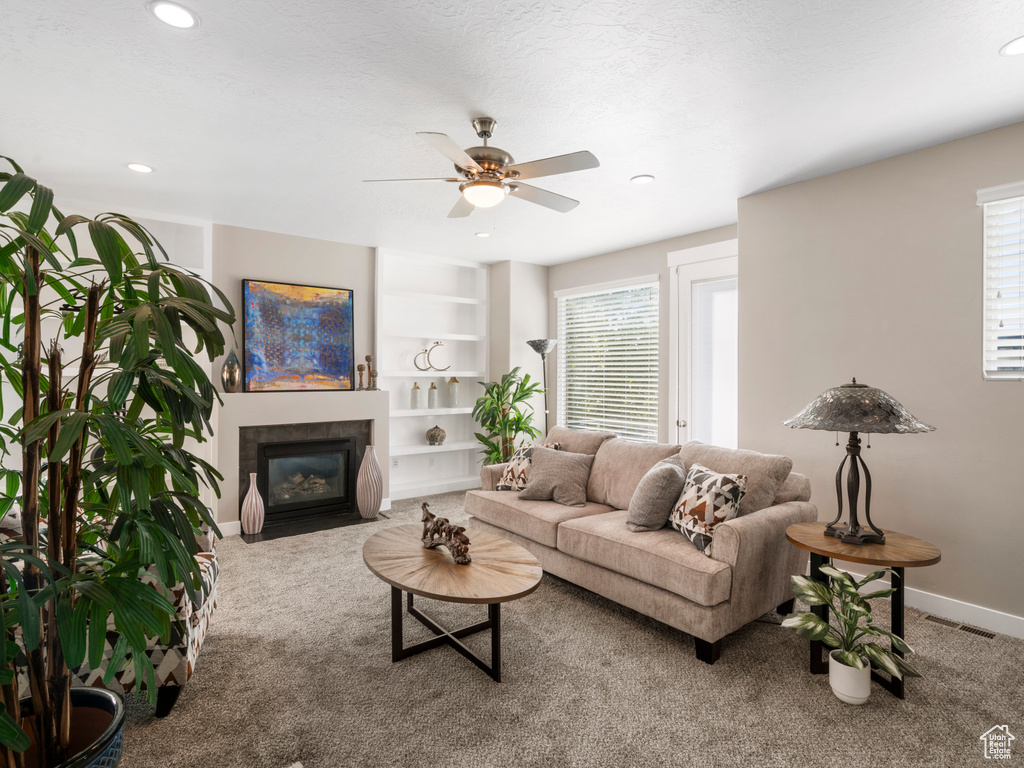 Living area with carpet, healthy amount of natural light, ceiling fan, and recessed lighting