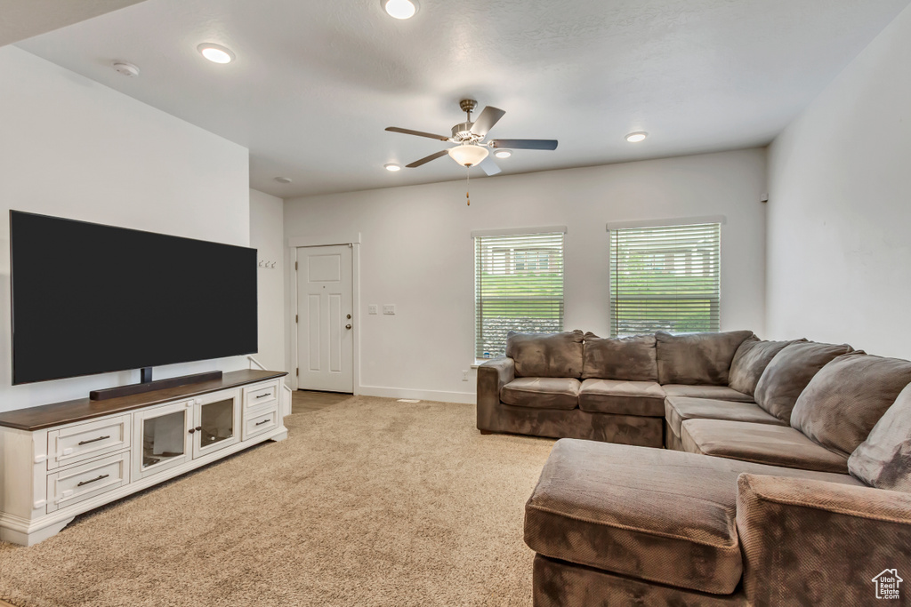 Living area featuring ceiling fan, light colored carpet, baseboards, and recessed lighting