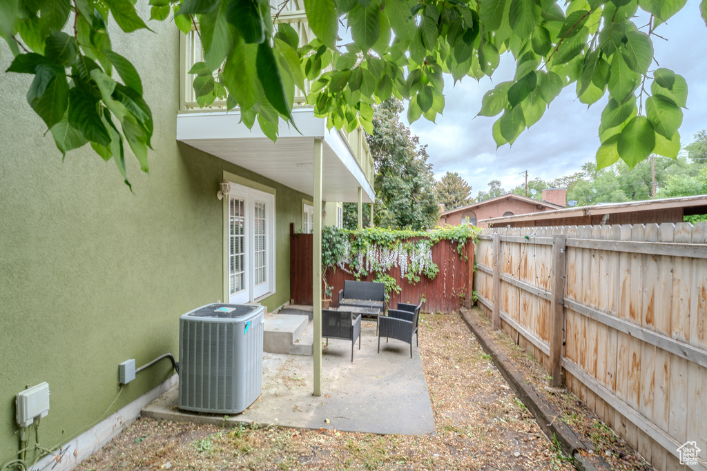 View of patio / terrace featuring central air condition unit, a fenced backyard, and french doors