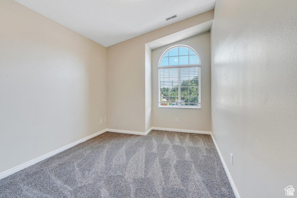 Empty room featuring carpet and baseboards