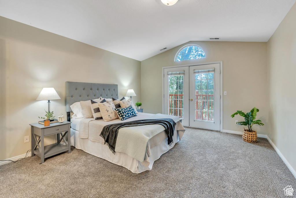 Carpeted bedroom with access to exterior, vaulted ceiling, baseboards, and french doors
