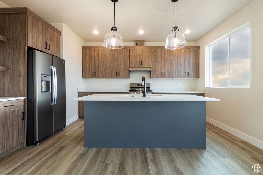 Kitchen featuring appliances with stainless steel finishes, a sink, light countertops, baseboards, and recessed lighting