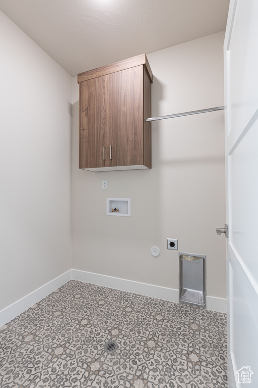 Laundry area with electric dryer hookup, cabinet space, baseboards, and washer hookup