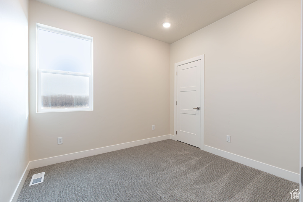 Carpeted empty room featuring baseboards
