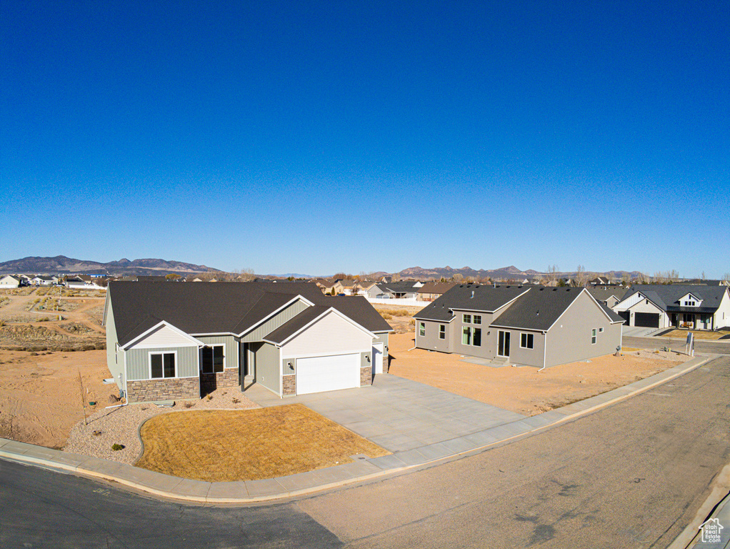 View of front facade with a residential view, a garage, a mountain view, and stone siding