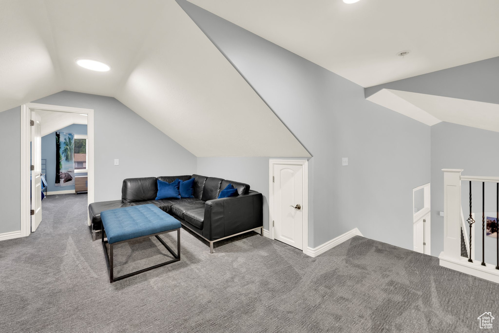 Living room with lofted ceiling, carpet flooring, and baseboards