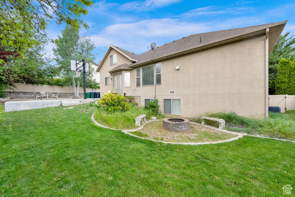 Back of property with a fire pit and stucco siding