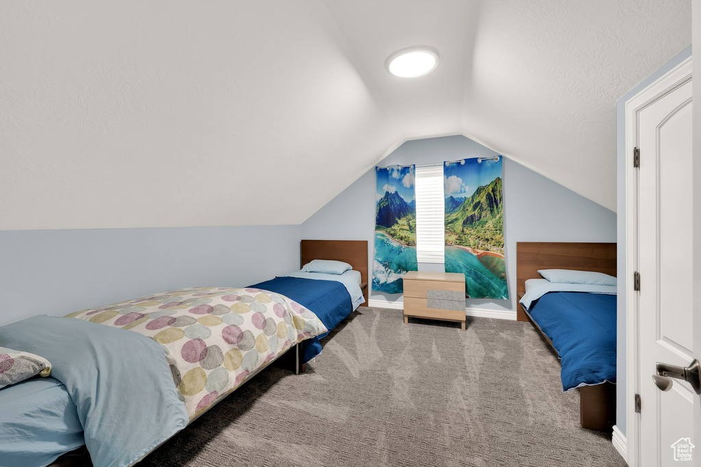 Bedroom featuring carpet, vaulted ceiling, and baseboards