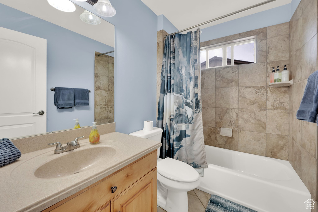 Full bathroom with toilet, vanity, shower / bath combination with curtain, and tile patterned floors