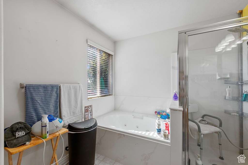 Bathroom featuring a shower stall and a tub with jets