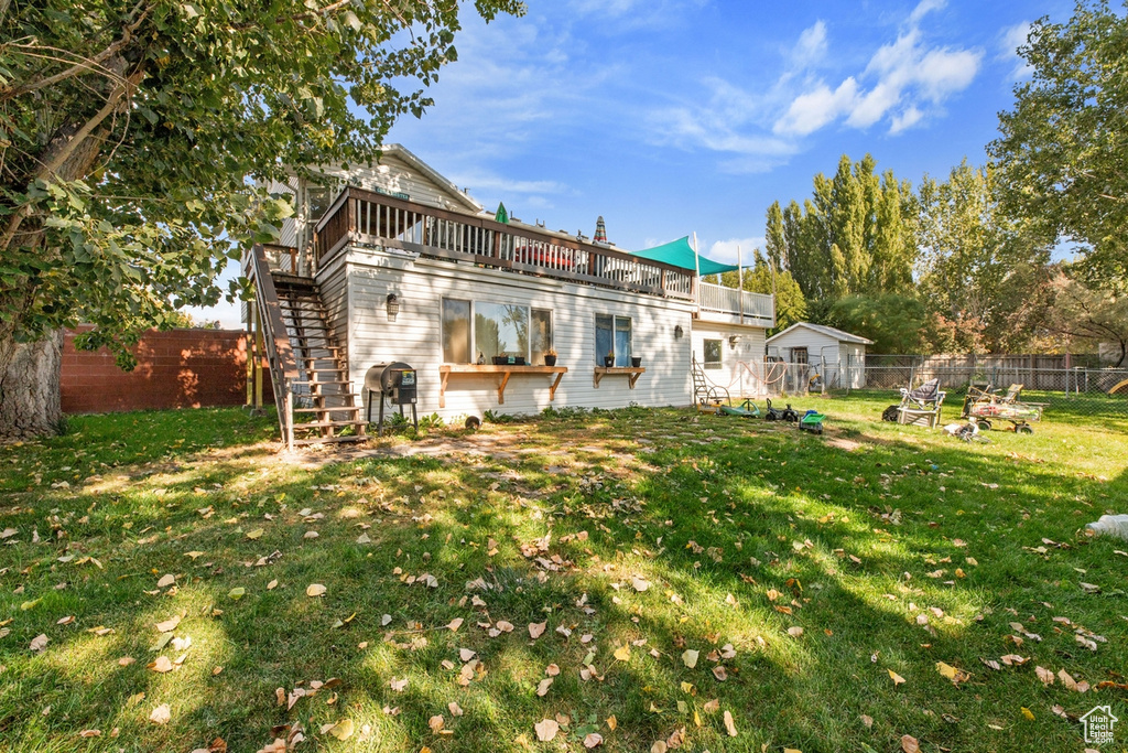 Rear view of house featuring stairway and a deck