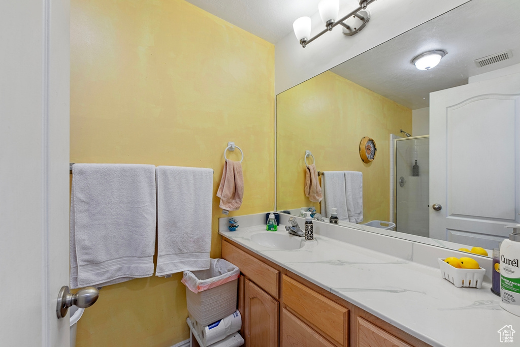 Full bath featuring a stall shower and vanity
