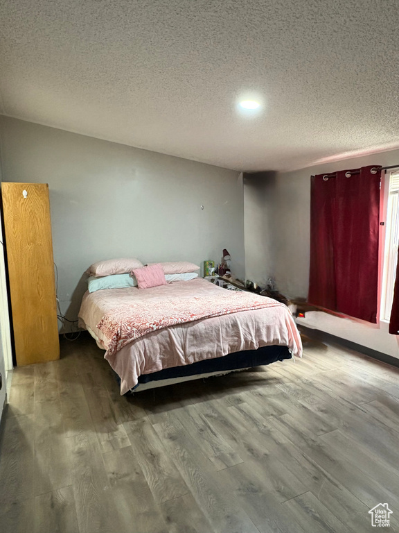 Bedroom featuring wood finished floors and a textured ceiling