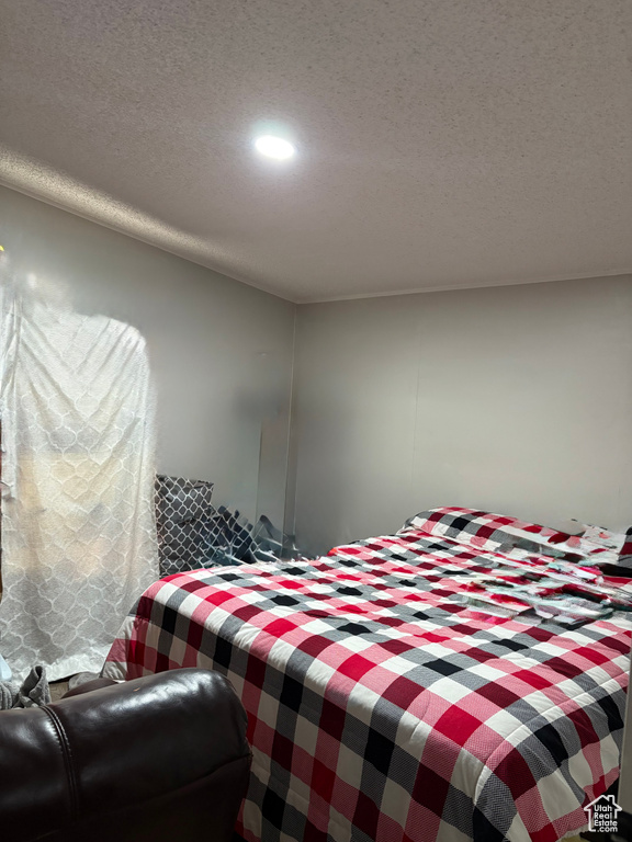 Bedroom with a textured ceiling and recessed lighting