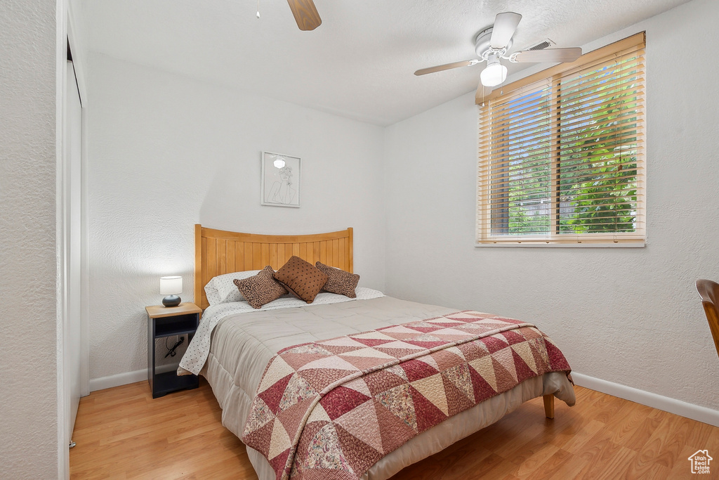 Bedroom featuring wood finished floors, baseboards, and a ceiling fan