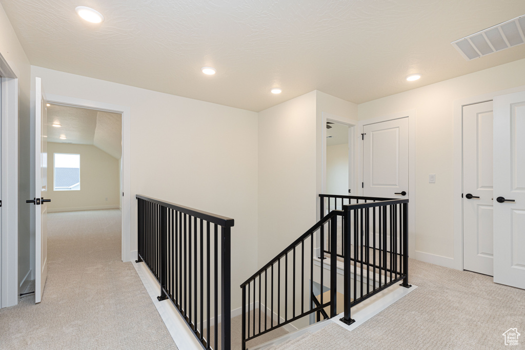 Hallway featuring an upstairs landing, light colored carpet, recessed lighting, and baseboards