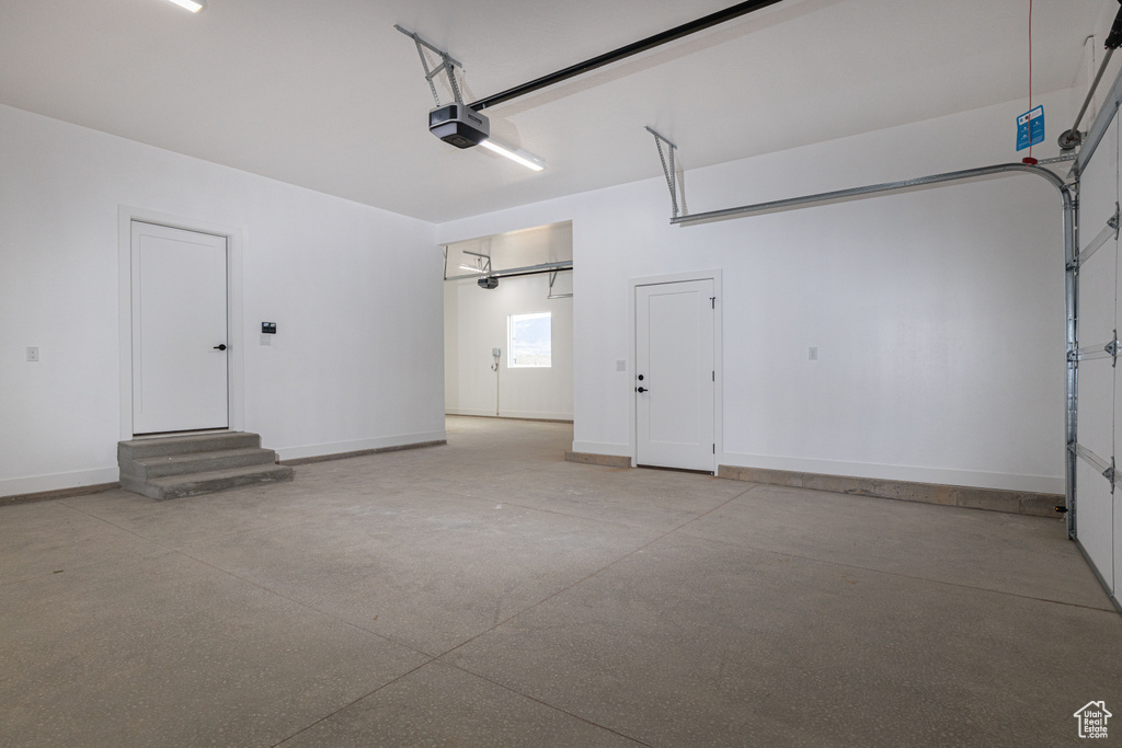 Garage with a garage door opener and baseboards