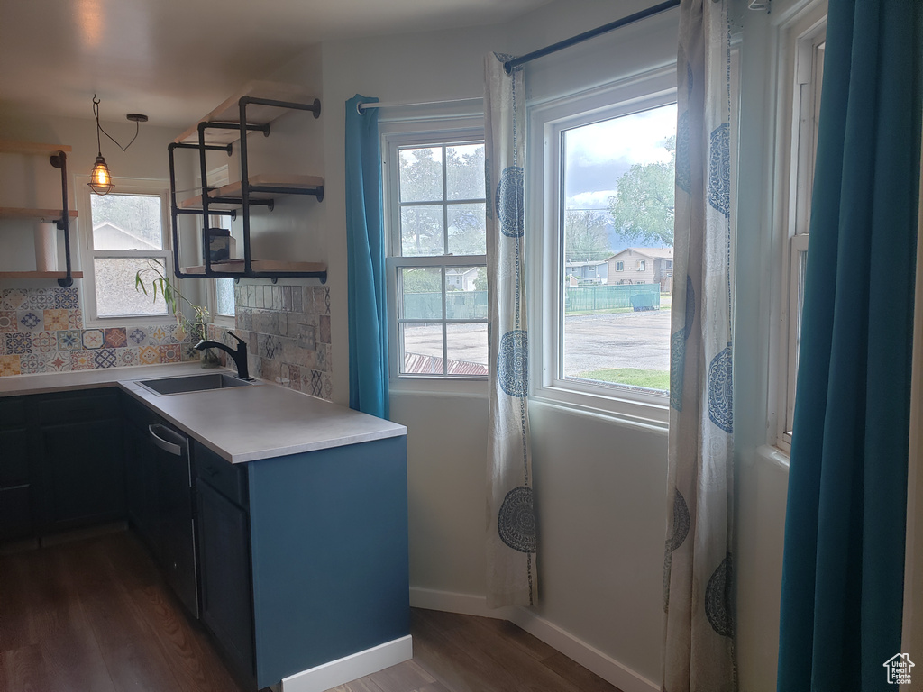 Kitchen with open shelves, backsplash, dark wood-style floors, and a sink