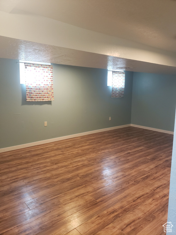 Below grade area featuring wood finished floors, baseboards, and healthy amount of natural light