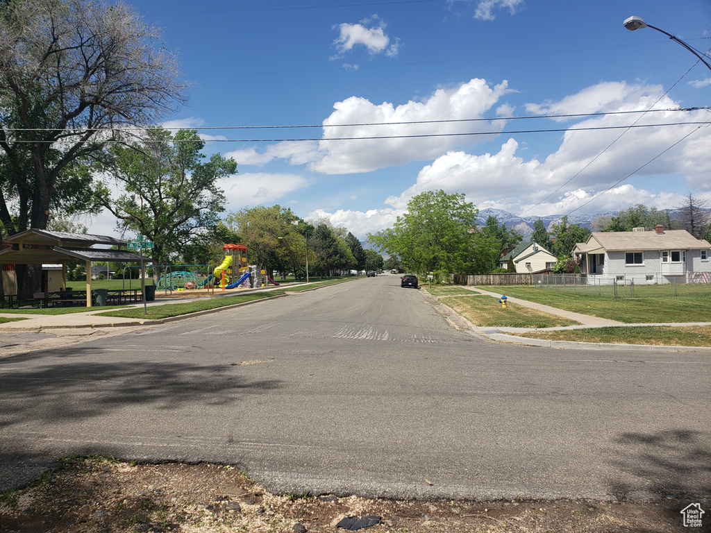 View of asphalt street with sidewalks, street lights, and curbs